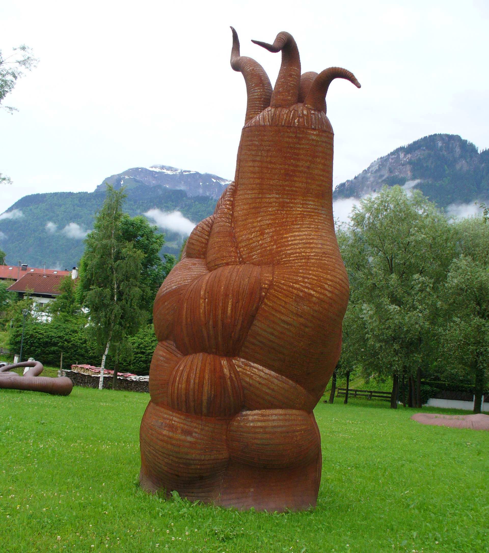 Mutterfigur des Setzlings: rostige Skulptur in einer grünen Parkanlage