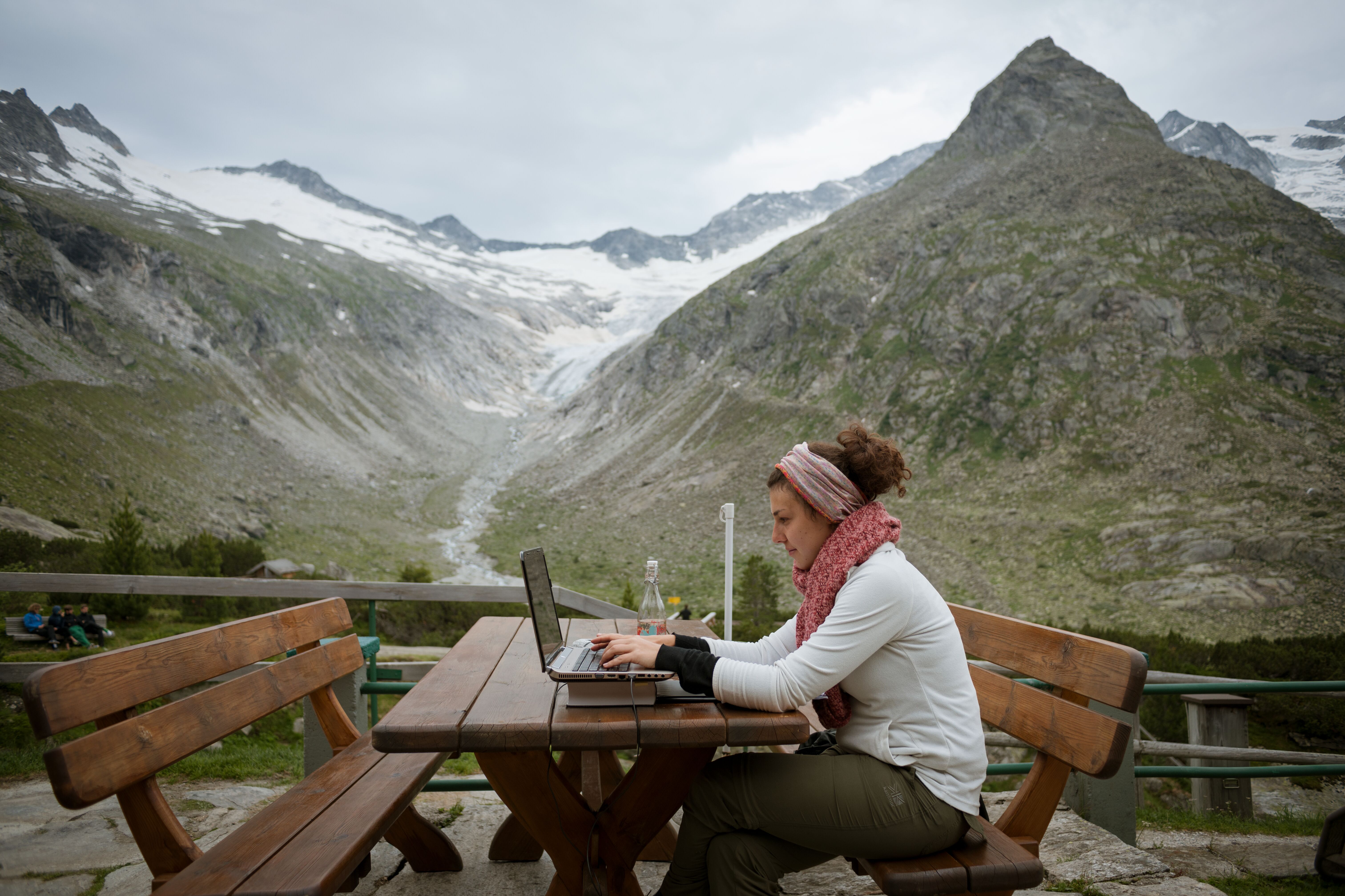 Frau am Laptop in den Bergen