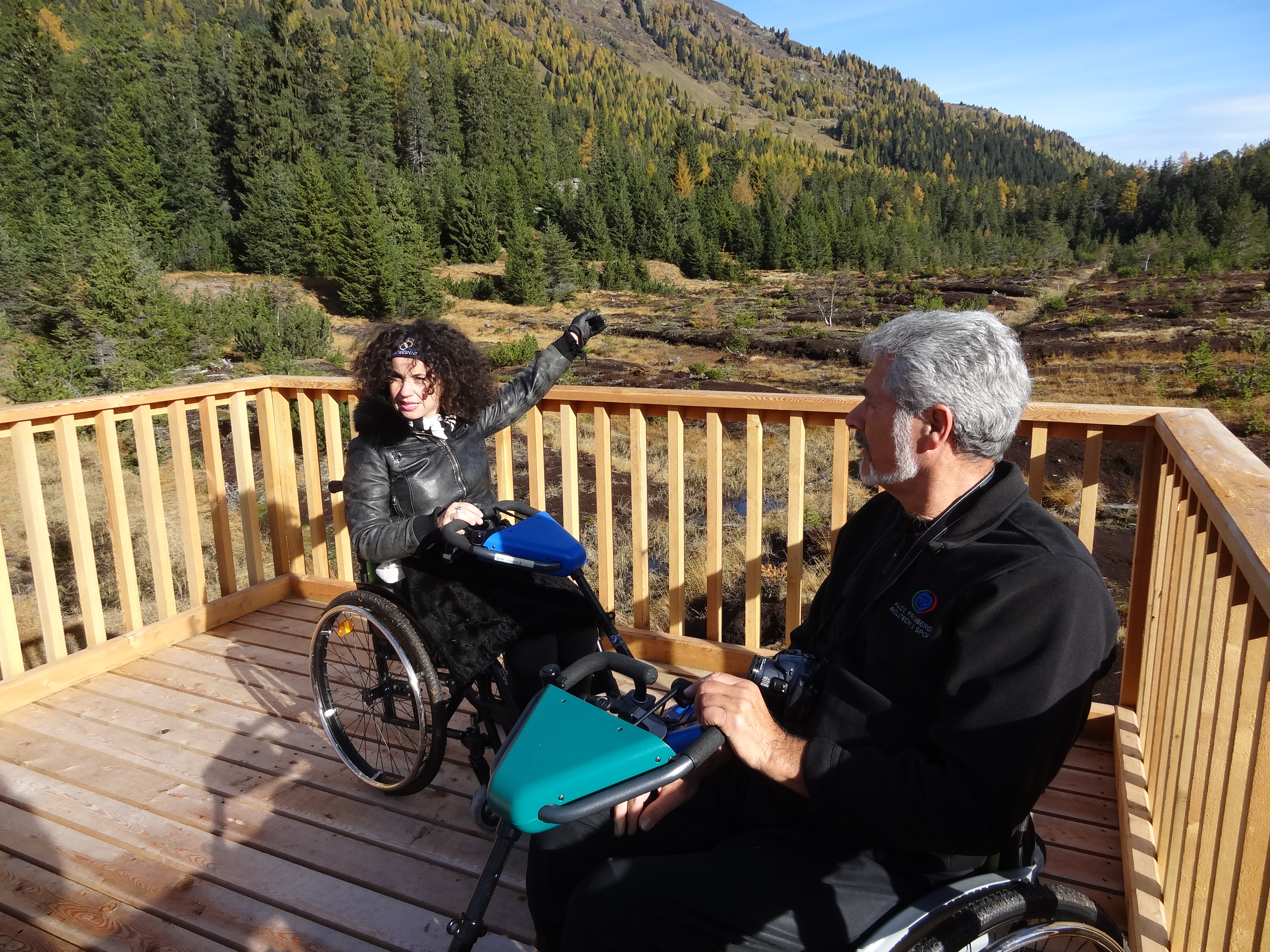 zwei Rohlstuhlfahrer:innen auf einem Aussichtspunkt in den Kaunertaler Alpen